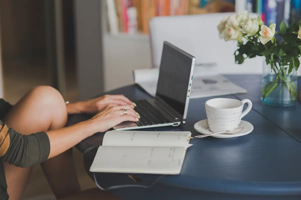 automatic blog writer laptop workspace with coffee and notebook